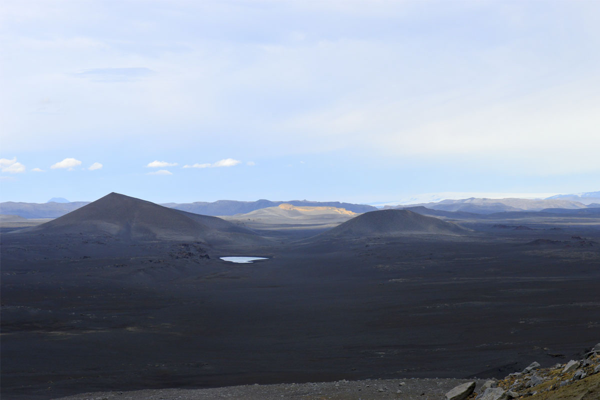 Horft á gíginn Mána baðaðan í sól í gegnum gíginn Font í Veiðivatnahrauni. Gígarnir eru sprengigígar af hverfjallagerð og mynduðust í sigdældinni Heljargjá sem liggur frá Landmannalaugum og norðaustur í Vatnajökul