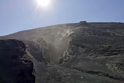 Vindar feykja til lausu efni úr gjóskubunkum en ekki hafði rignt í eynni frá í lok júní. 